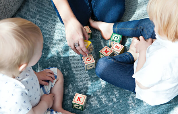 Bambini che giocano con le lettere dell'alfabeto sul tappeto