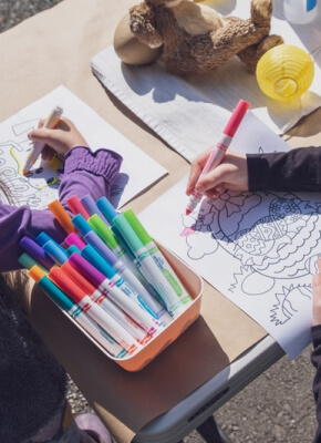 Bambino che disegna con i pennarelli colorati al tavolo