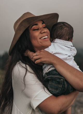 Educatrice sorridente che tiene in braccio un bambino